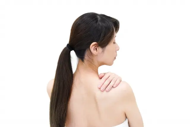 背中のフケ具合を気にする女性
