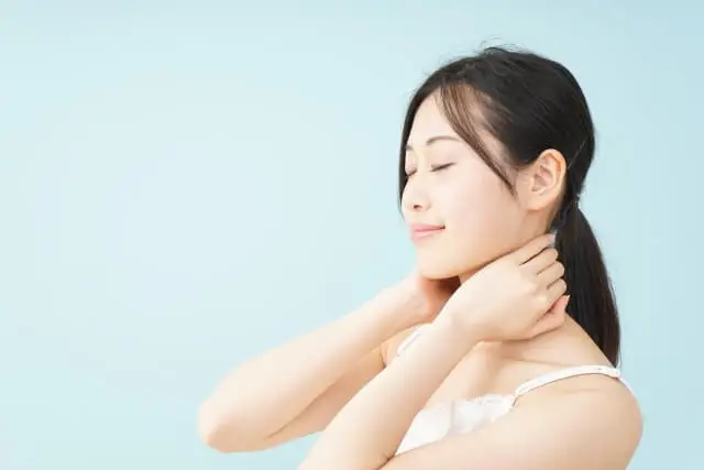首のこりが気になり、首すじに手を当てる女性首のこりが気になり、首すじに手を当てる女性