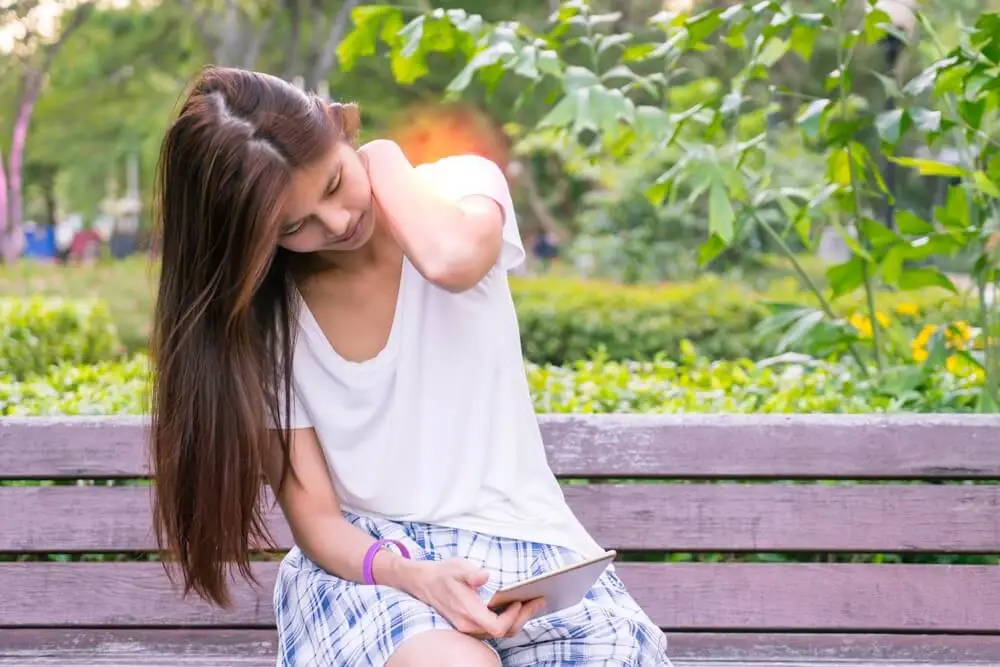 スマホの使いすぎで、首こりが気になって集中できない女性