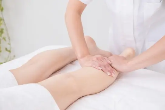 足のリンパマッサージを受ける女性